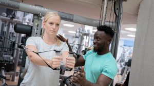 A man and a woman training in a gym for their Personal Trainer course