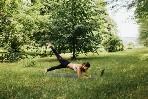 female performing pilates outdoor in a woods