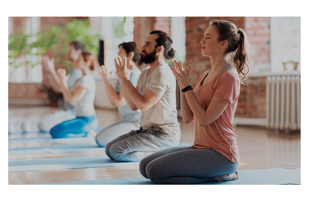 Yoga class pictured on their knees with a blonde female at the front
