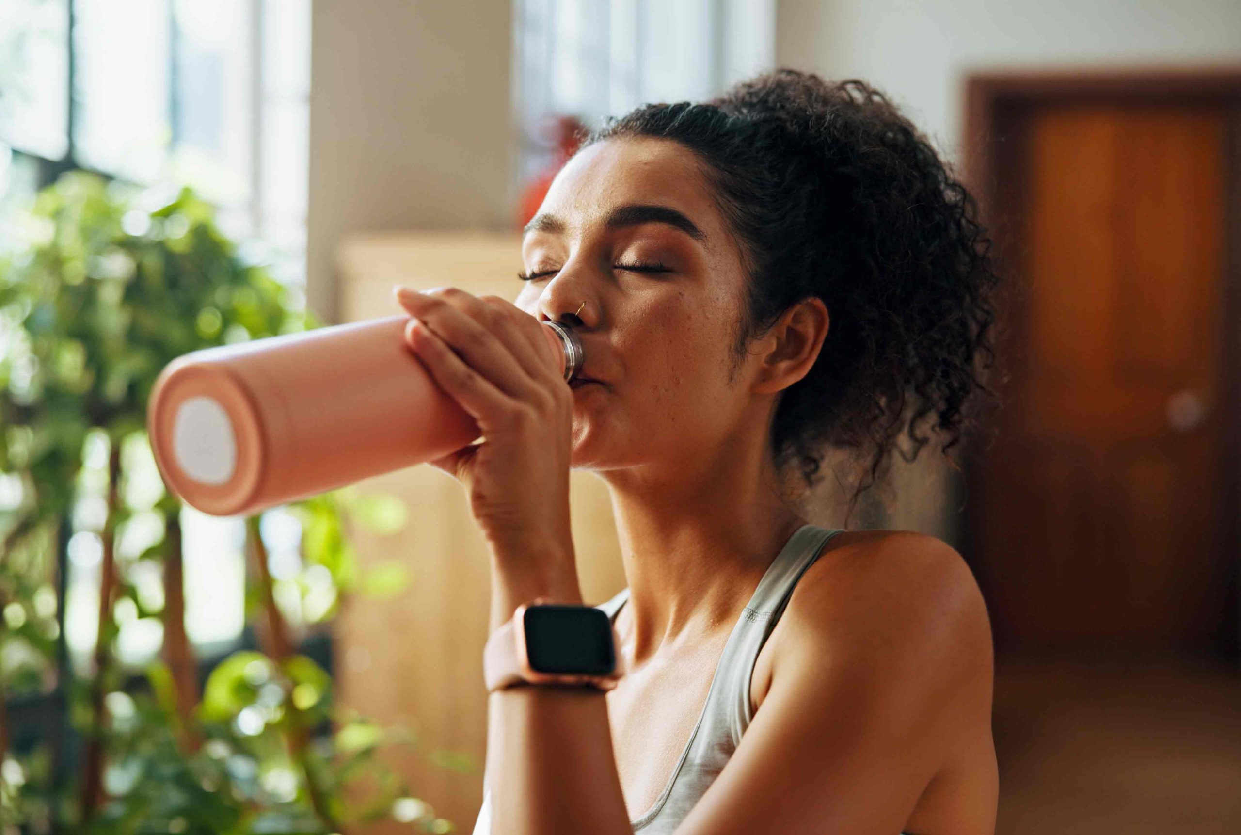 Woman drinking from a pink bottle