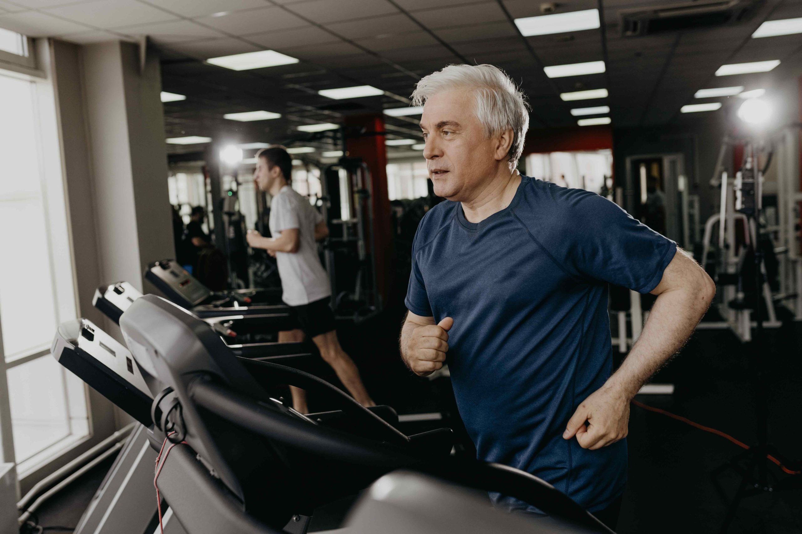 older adult on a treadmill at the gym